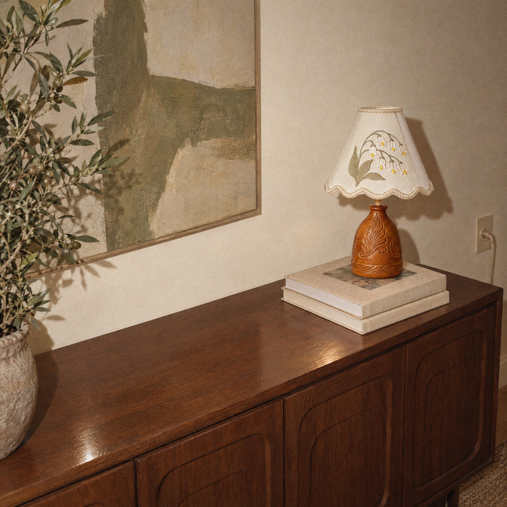 Lily of the Valley table lamp on a sideboard seen from above, with its shadow on the wall