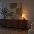 Lily of the Valley table lamp switched on at dusk, the shade glowing warm in a dim room