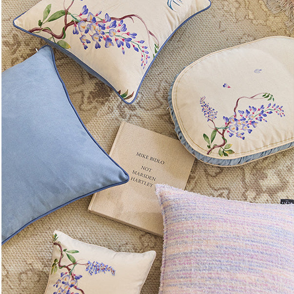 Decorative pillows with floral embroidery on a textured surface
