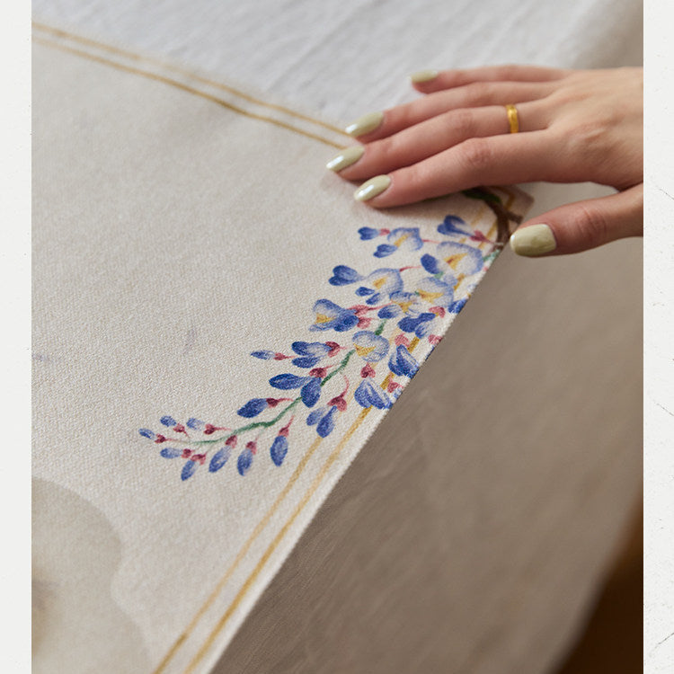 Hand holding a piece of paper with floral design on a wooden surface