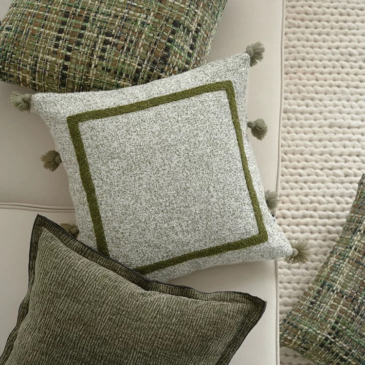 Textured green and gray cushions on a floor with carpet.