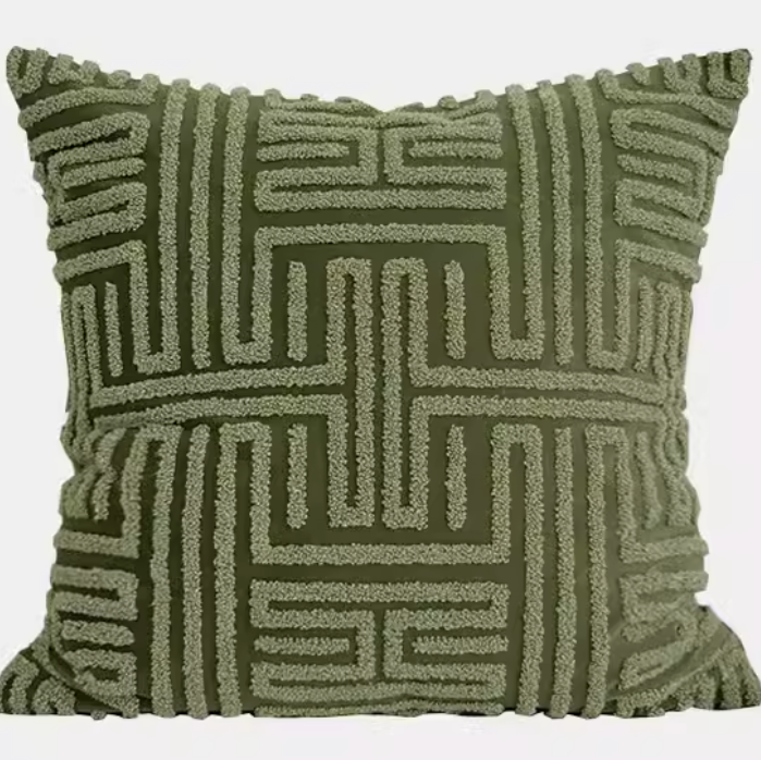 Green pillow with geometric pattern on a white background