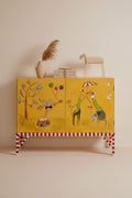 Yellow cabinet with cartoon designs on a beige wall