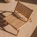 Woven chair on a textured surface with warm lighting