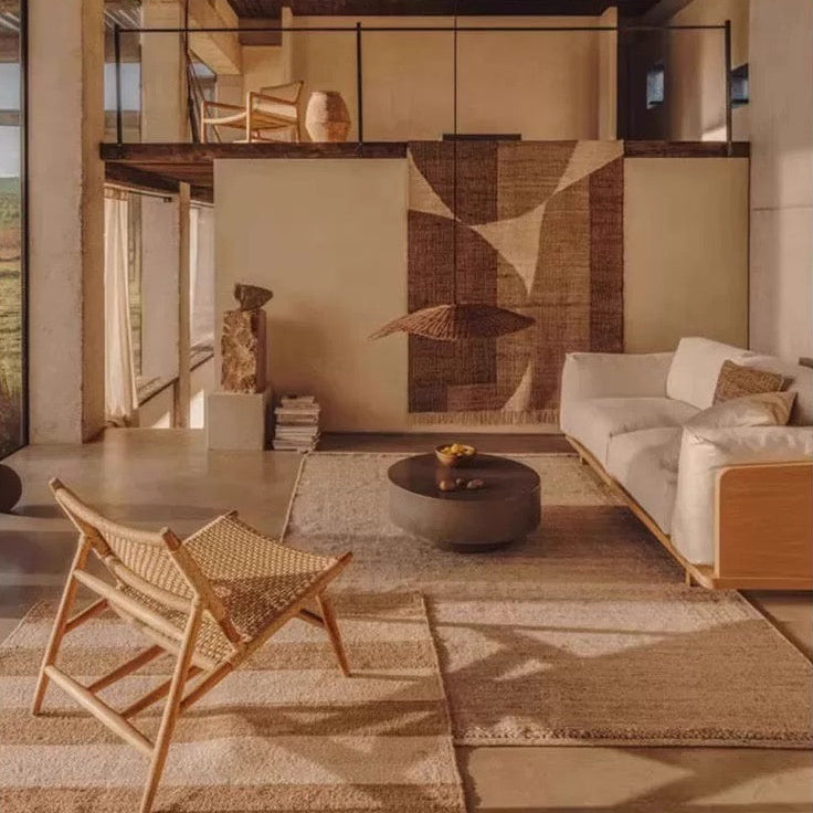 Modern living room with wooden chair, sofa, and decorative elements.
