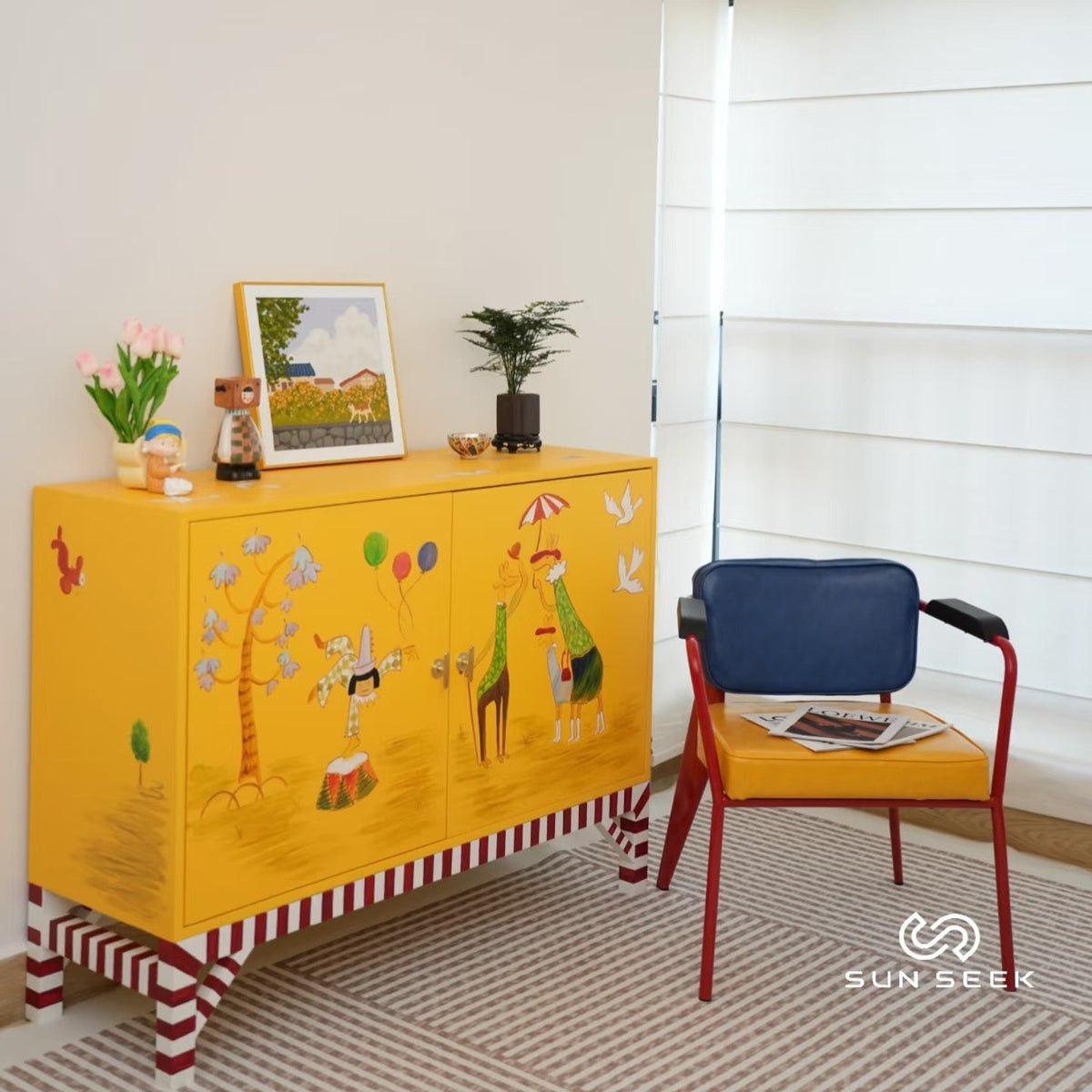 Yellow cabinet with animal illustrations in a room with a blue chair and a window.