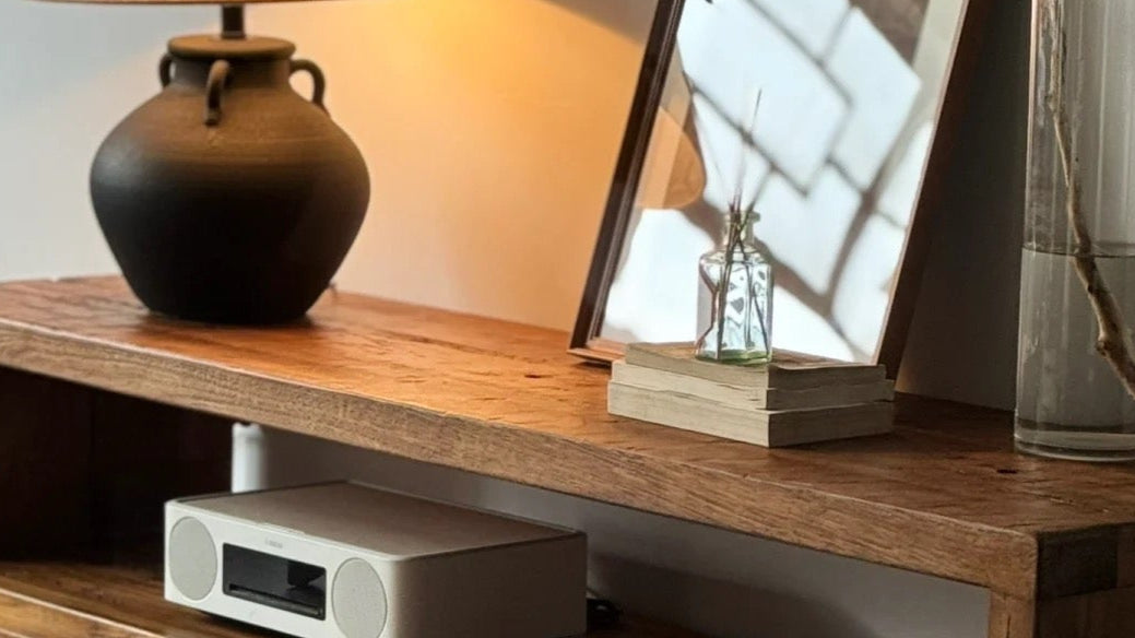 Wooden TV stand with decorative items in a living room setting