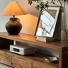Wooden TV stand with decorative items in a living room setting