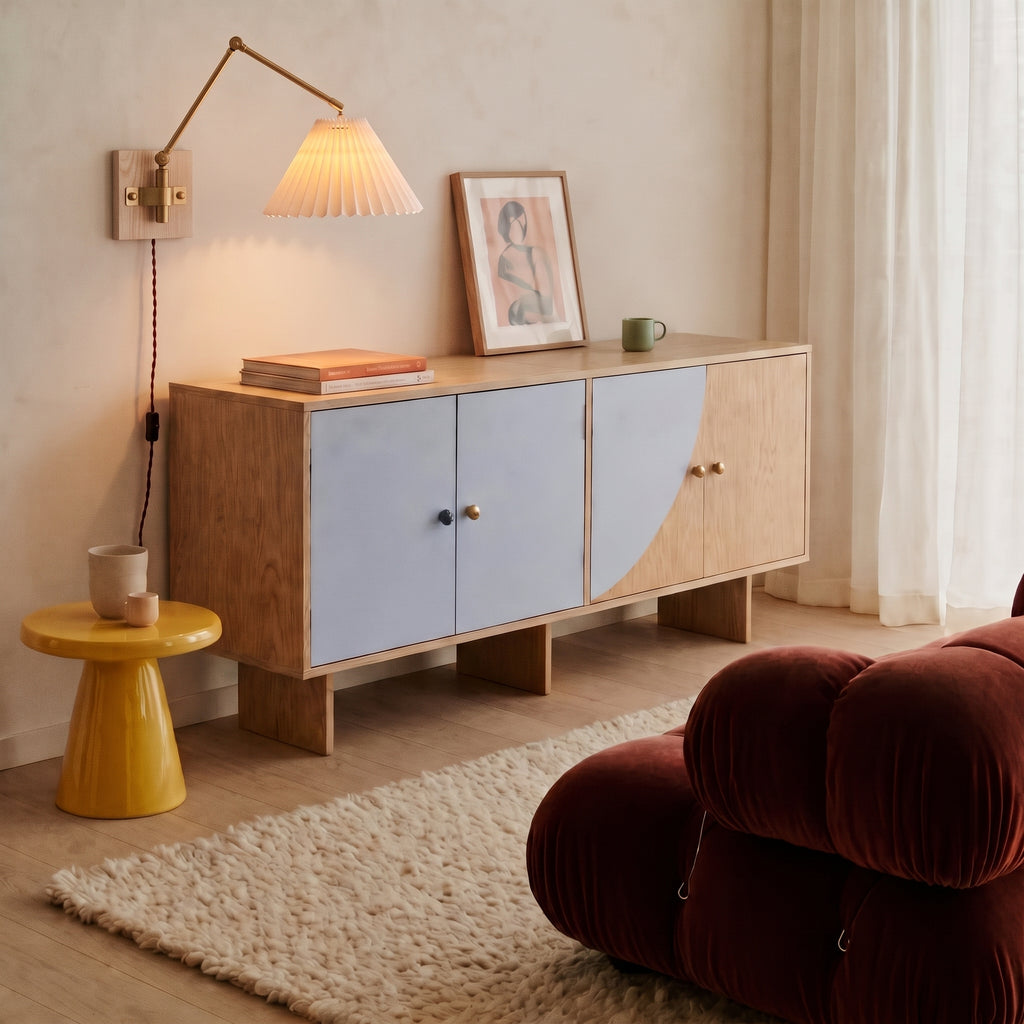 Plug-in swing arm wall sconce with a lit pleated shade above a wooden sideboard in a living room
