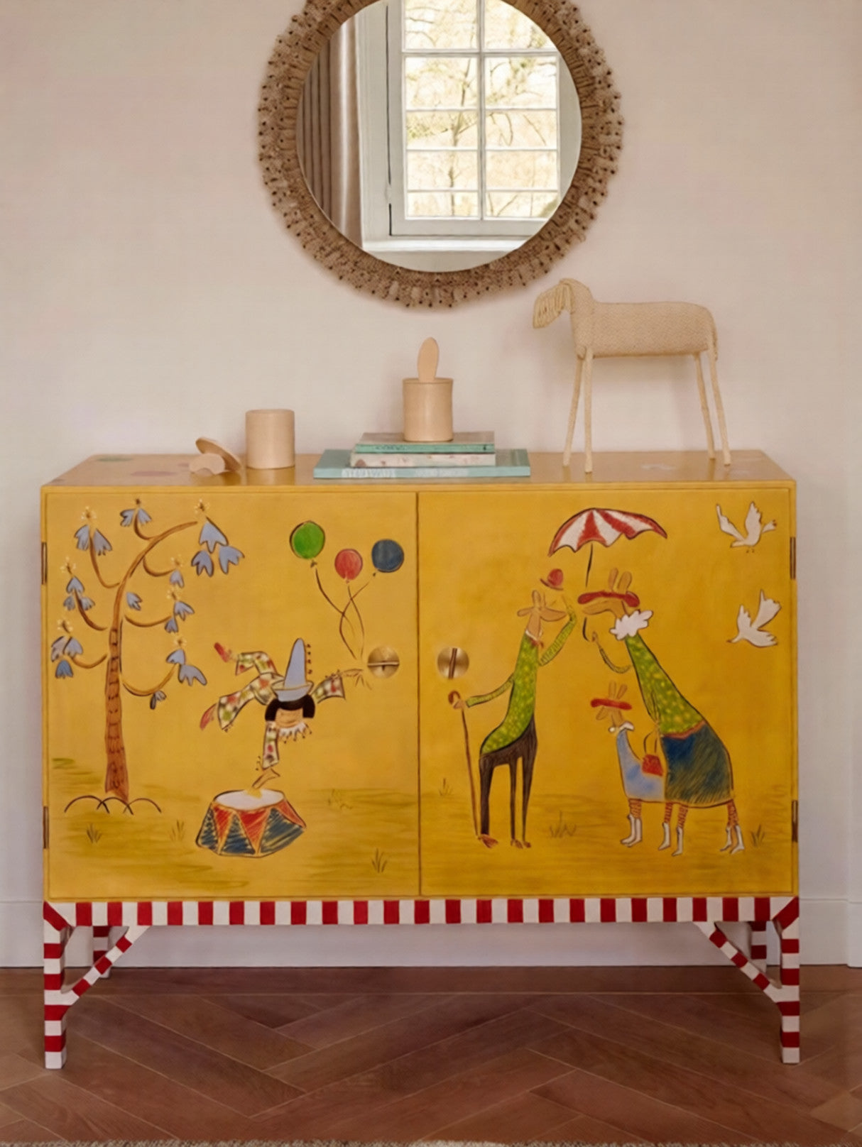 Yellow cabinet with colorful animal illustrations on a wooden floor.