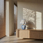 The Blue Wave on a low wooden sideboard, afternoon light falling through window blinds