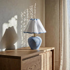 The Blue Wave on a wooden chest of drawers, dappled sunlight on the wall behind