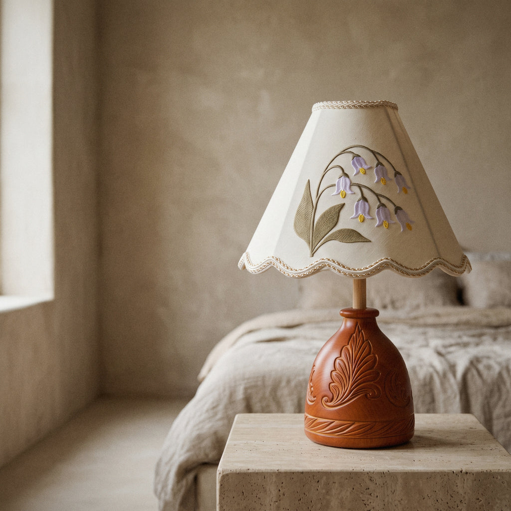 Close view of the embroidered lily of the valley sprig and scalloped hem of the lamp shade