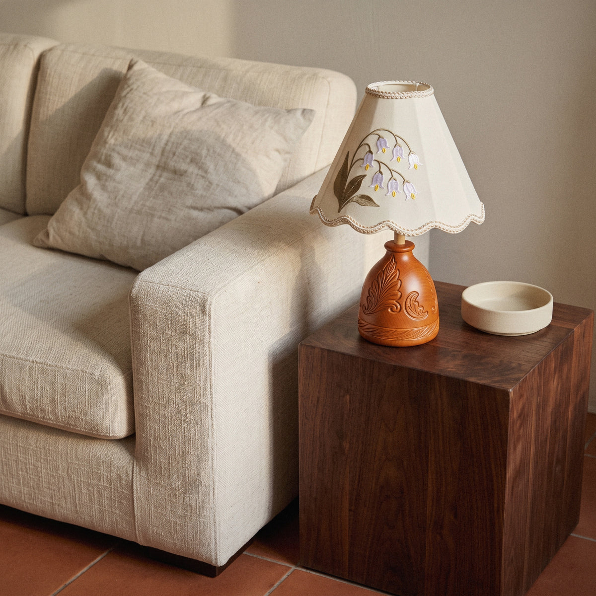 Lily of the Valley table lamp with carved wood base, in a room