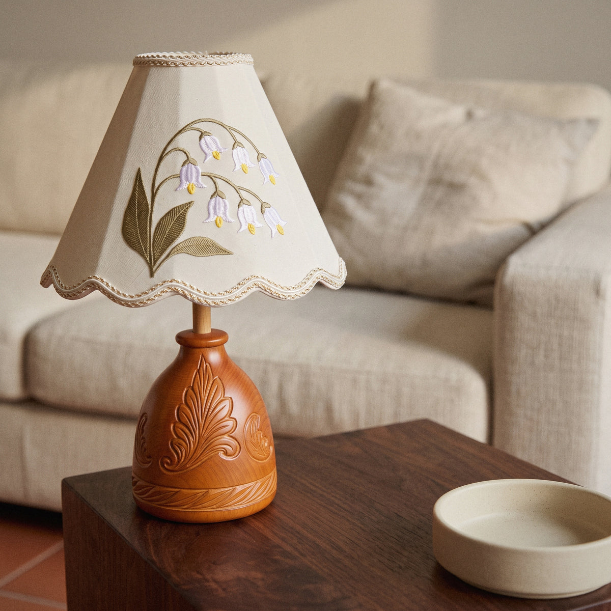 Lily of the Valley table lamp with embroidered shade and carved wood base, in a room
