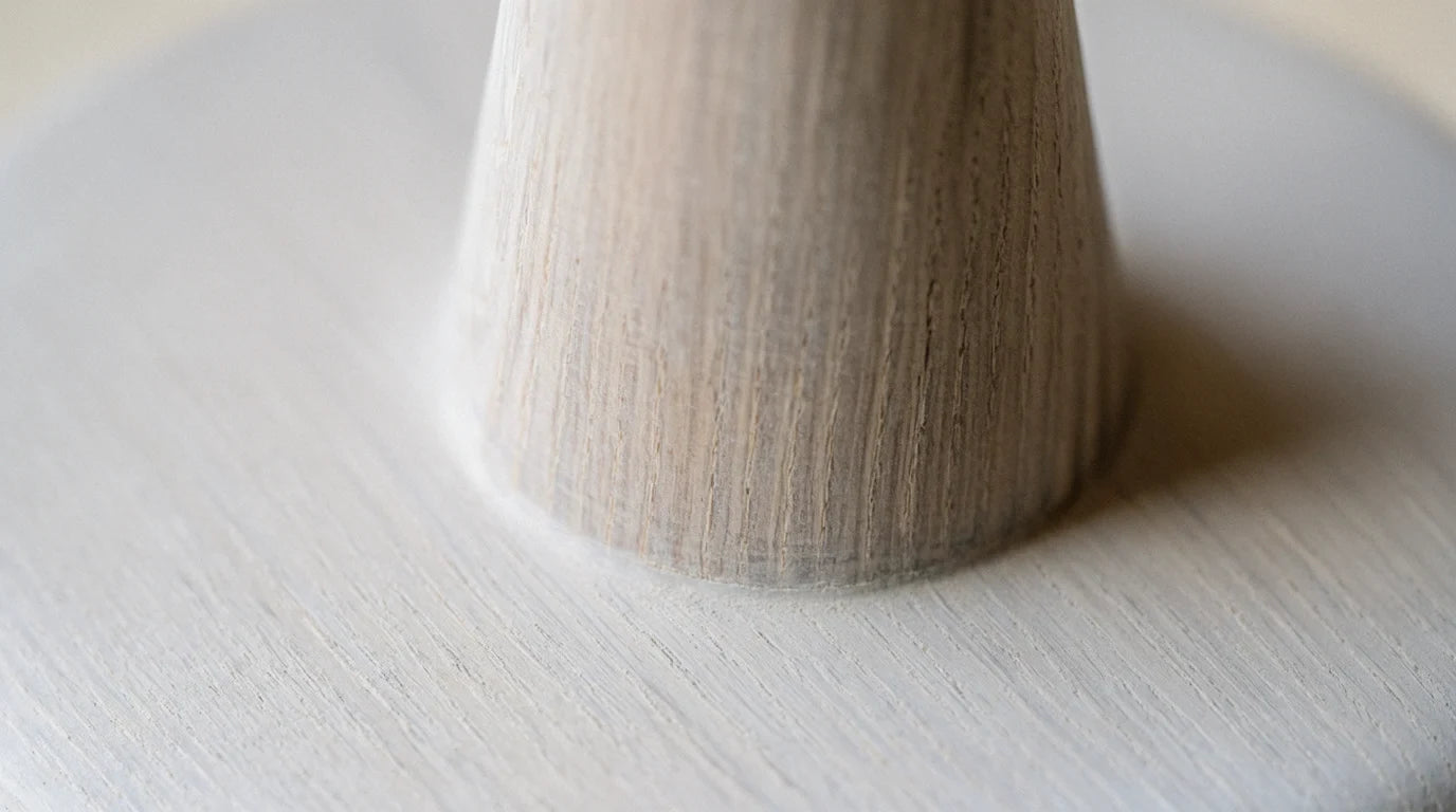 Close-up of a turned pale wood lamp neck with fine grain