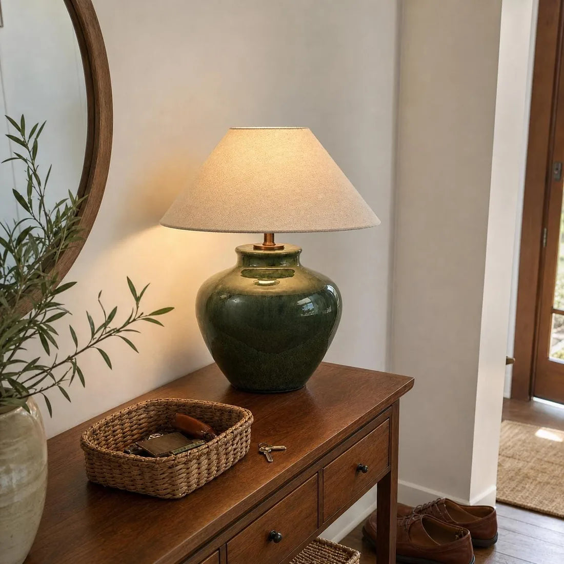 Green crackle-glaze ceramic table lamp with a linen shade on a wooden console